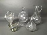 three clear glass vases and a small glass vase on a table