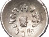 a close up of a silver coin on a white surface