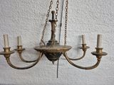 a chandelier hanging from the ceiling with candles on it