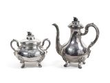 pair of silver plated teapots and sugar bowl on stand