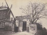 une vieille photo d'un bâtiment avec un moulin à vent en arrière-plan