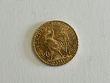a close up of a gold coin on a white surface