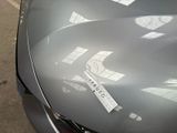 a sticker on the hood of a car that is parked in a parking lot