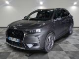 the front of a grey car on a checkered floor in a garage