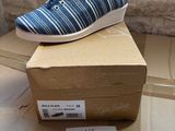 blue and white striped shoes on top of a box on a table