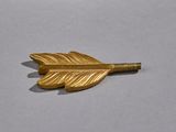 gold leaf shaped broocht on a white surface