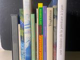 une pile de livres posée sur une table à côté d'une valise noire