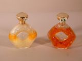 trois flacons de parfum posés les uns à côté des autres sur une surface blanche