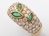 a close up of a gold ring with green and white stones