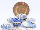plusieurs assiettes, tasses et soucoupes bleues et blanches posées sur une surface blanche