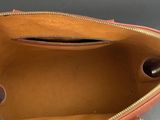 the inside of an orange purse with a zipper on it