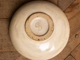 a white bowl sitting on a wooden floor