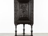 une vieille armoire en bois dont la façade est ornée de motifs sculptés