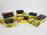 trois jouets représentant des véhicules militaires, emballés dans leur boîte, posés sur une surface blanche