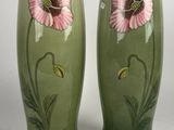 une paire de vases verts ornés de fleurs roses sur fond blanc