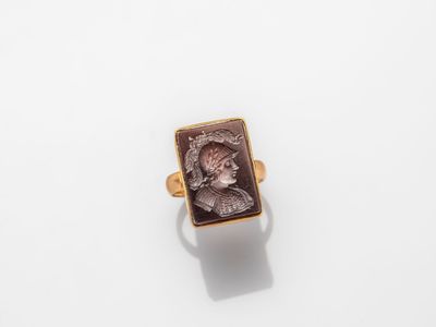 a gold ring with an image of a woman in profile