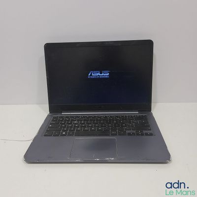 L'ordinateur portable Asus est posé sur une table blanche équipée d'un clavier noir.