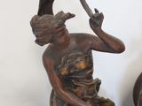 a bronze statue of a woman with a bird on her shoulder