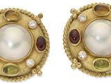 une photo d'une paire de boucles d'oreilles ornées de perles et de pierres précieuses