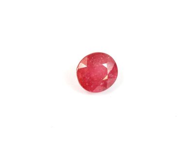 gros plan d'une pierre de rubis rouge sur une surface blanche