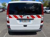 a white van with red stripes parked in a parking lot