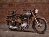 a old motorcycle that is parked in front of a brick wall