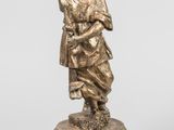 une figurine antique en bronze représentant une femme tenant un enfant dans ses bras