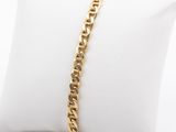 a close up of a gold chain bracelet on a pillow