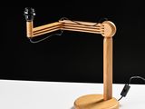a close up of a wooden desk lamp on a white surface
