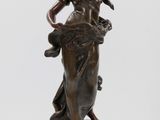 une statue en bronze d'une femme tenant un oiseau sur un piédestal
