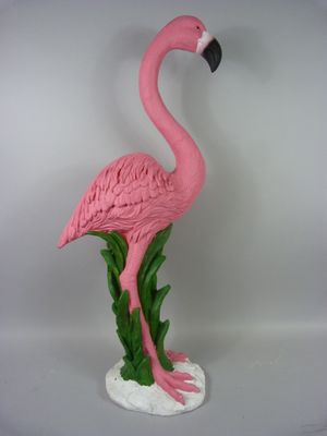 un flamant rose posé sur un socle blanc
