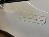 a sticker on the door handle of a white car