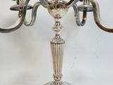 un candélabre en argent surmonté de deux bougies