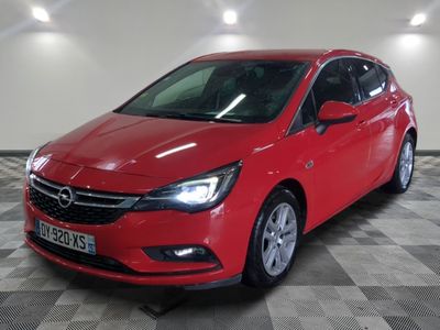 a red opel parked in a garage with a checkered floor