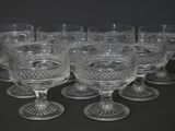 six clear glass goblets sitting on top of each other on a black surface