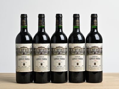 quatre bouteilles de vin sont alignées sur une table en bois