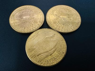 three gold coins sitting on top of each other on a table