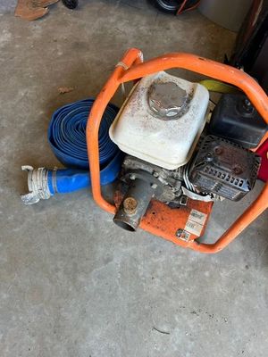 a small engine sitting on the floor next to a hose