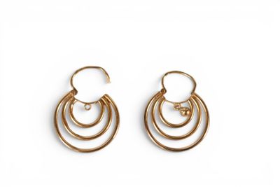a pair of gold hoop earrings on a white background