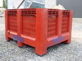 a red crate sitting on top of a gravel field