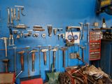 many tools hanging on a blue wall in a garage