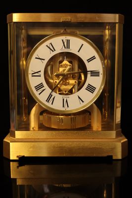 a gold clock with roman numerals on the face