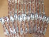 many forks and spoons wrapped in plastic bags on a table