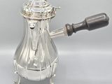 an antique silver coffee pot with a wooden handle on a white background