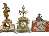 several different types of clocks and figurines are displayed on a white surface