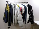 de nombreuses vestes suspendues à un porte-manteau dans une pièce