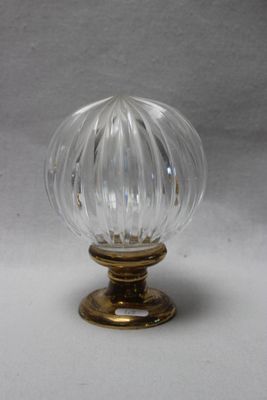 une image représentant une poignée de porte en verre transparent montée sur un support doré
