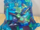 un sac de jouets en plastique posé sur une table en bois