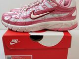 a pink and white nike running shoe on top of a box