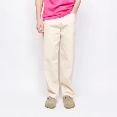a man in a pink shirt and khaki pants posing for a picture
